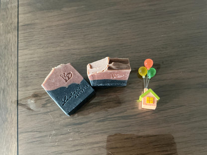 Top view of Meliya Aanmai soap bars showing the charcoal and rose-brown layers and handmade finish