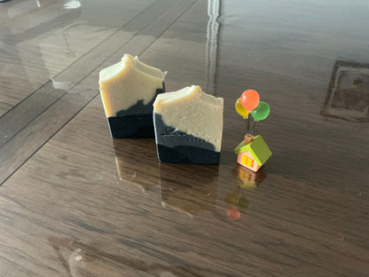 Two Obsidian soap bars with handmade layer patterns and Lustera Naturals stamps
