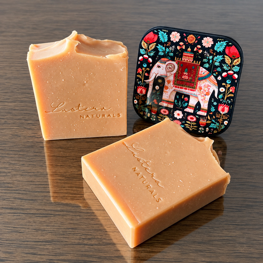 Two Lustera Naturals Sandalwood soap bars, one standing and one lying flat, beside a decorative elephant coaster